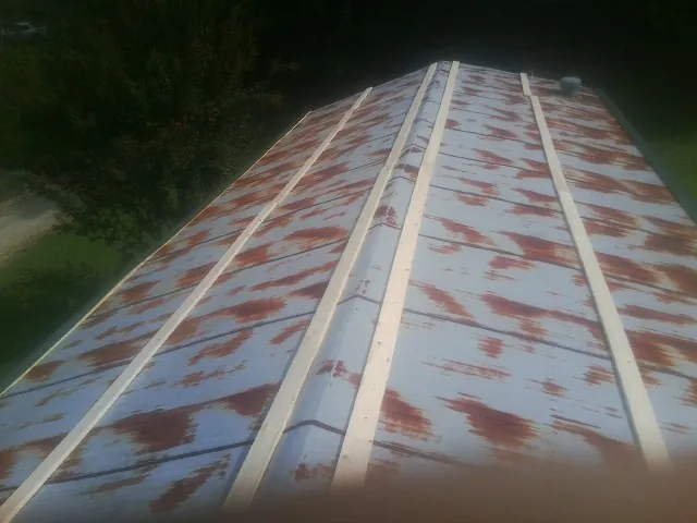 Rusted metal roof panels with new wood purlins before replacement — Storm Damage Roof Repair in Wingate by Roofing Brothers
