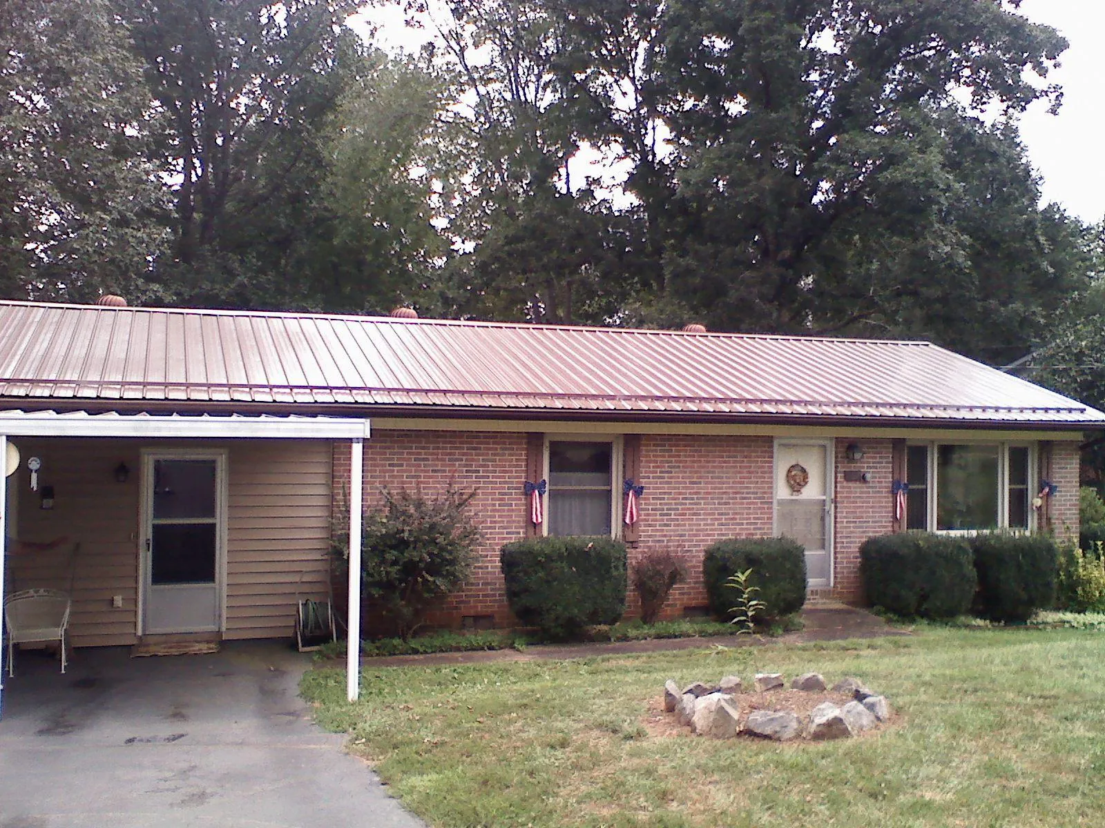 Bronze metal roof and carport on a brick ranch home — Roof Repair work by our crew in Wingate