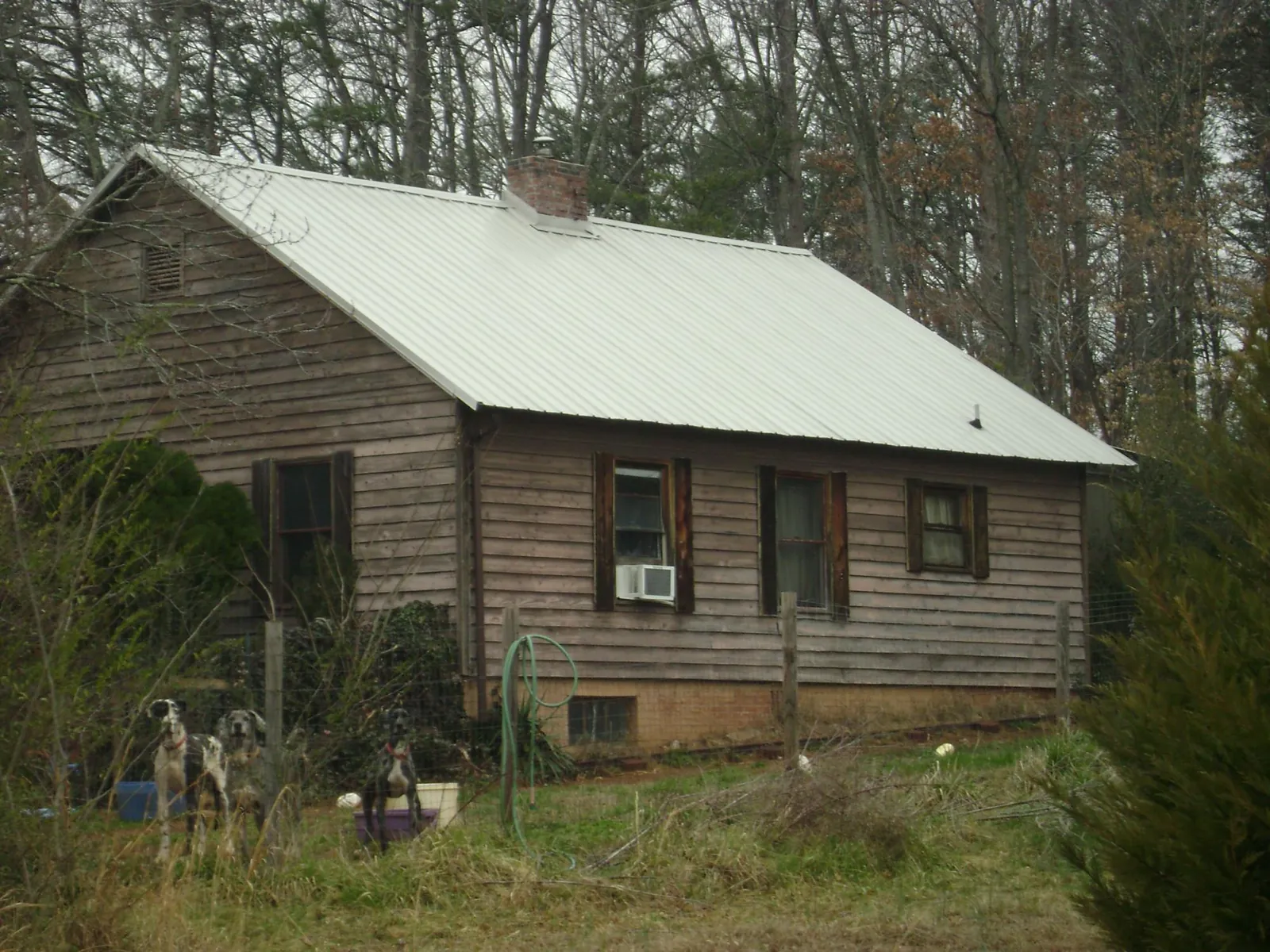 White metal roof on an old wood sided farmhouse, from a Asphalt Shingle Roof Repair job in Wingate